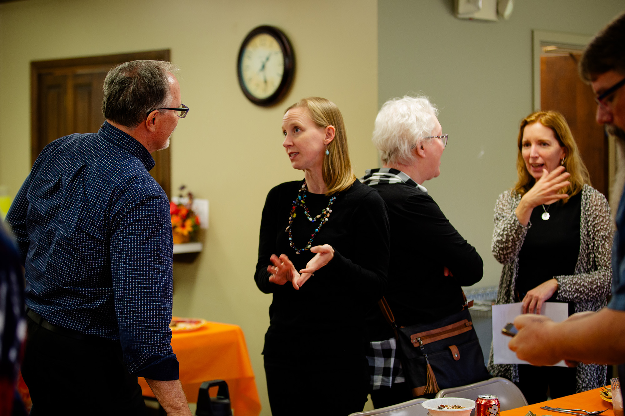 Four people chat after a meeting.