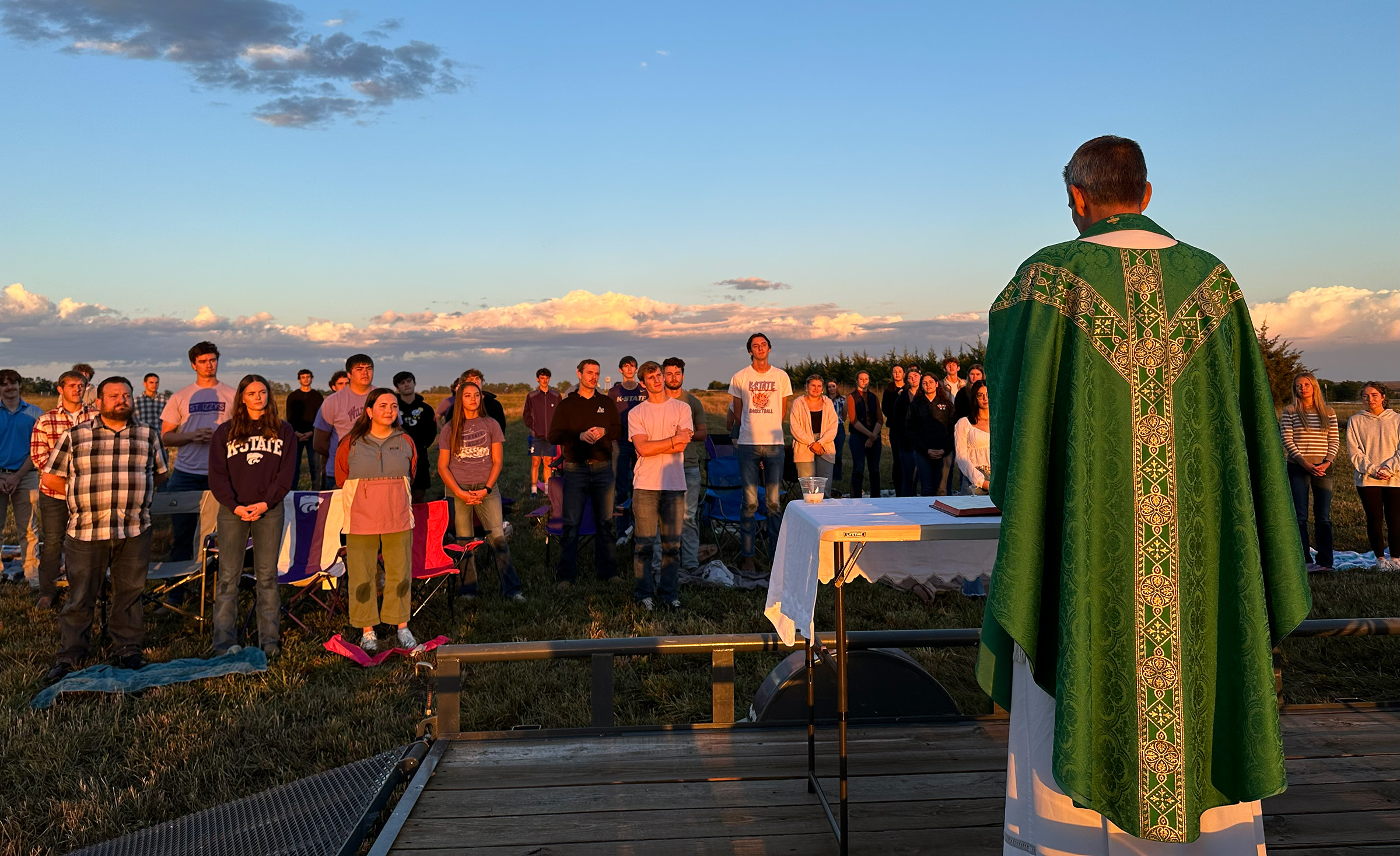 a priest leads outdoor mass