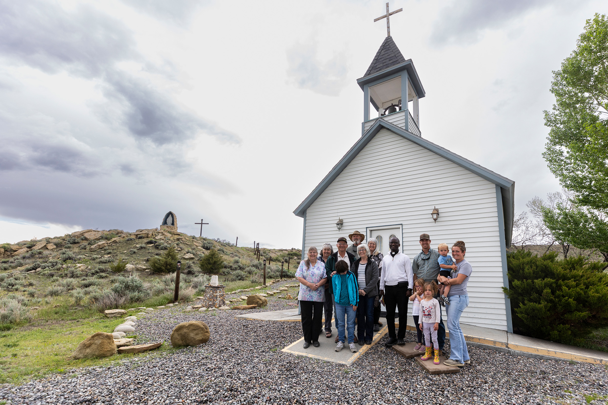People stand in front of a small church